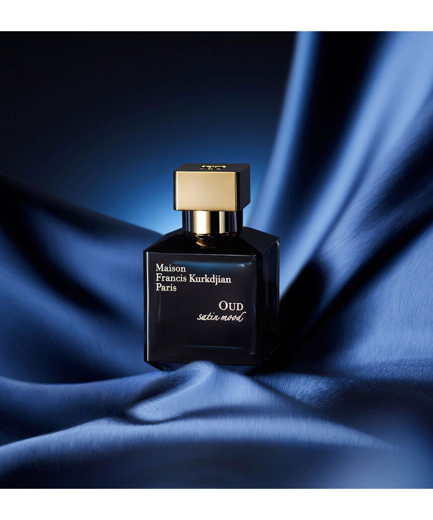 Oud Satin Mood de Maison Francis Kurkdjian sobre tela de satén azul