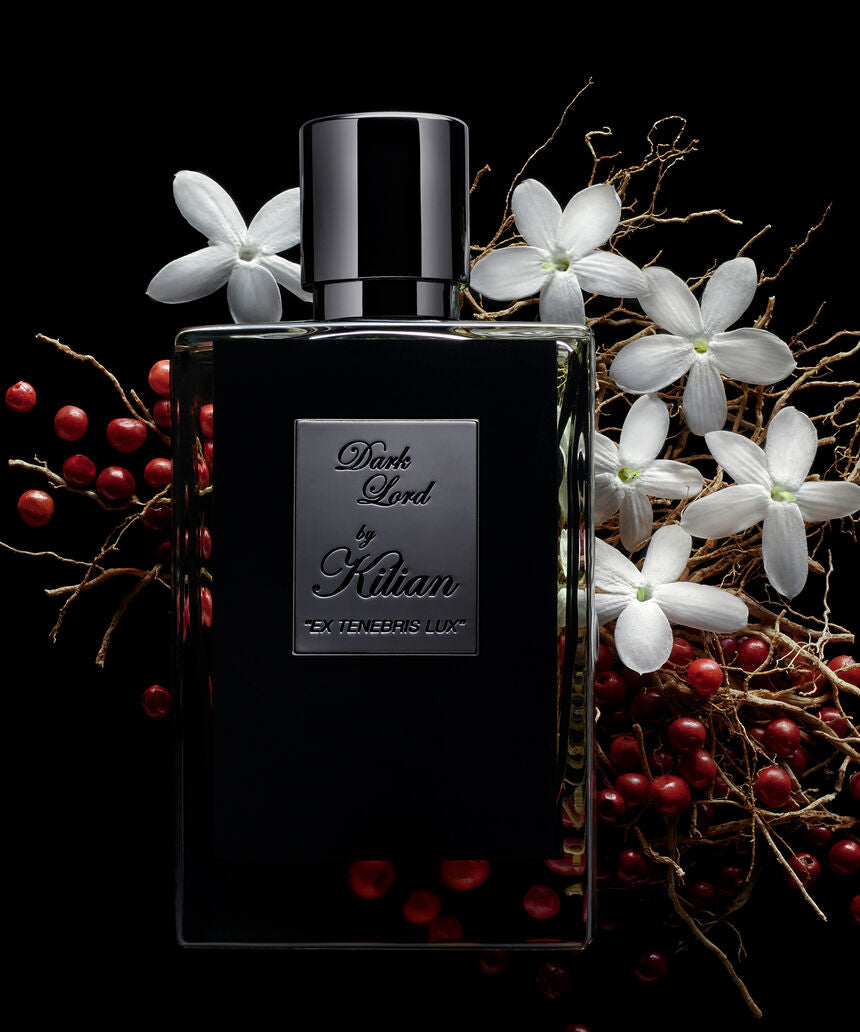 Dark Lord Ex Tenebris Lux de Kilian Paris entre flores blancas y bayas rojas